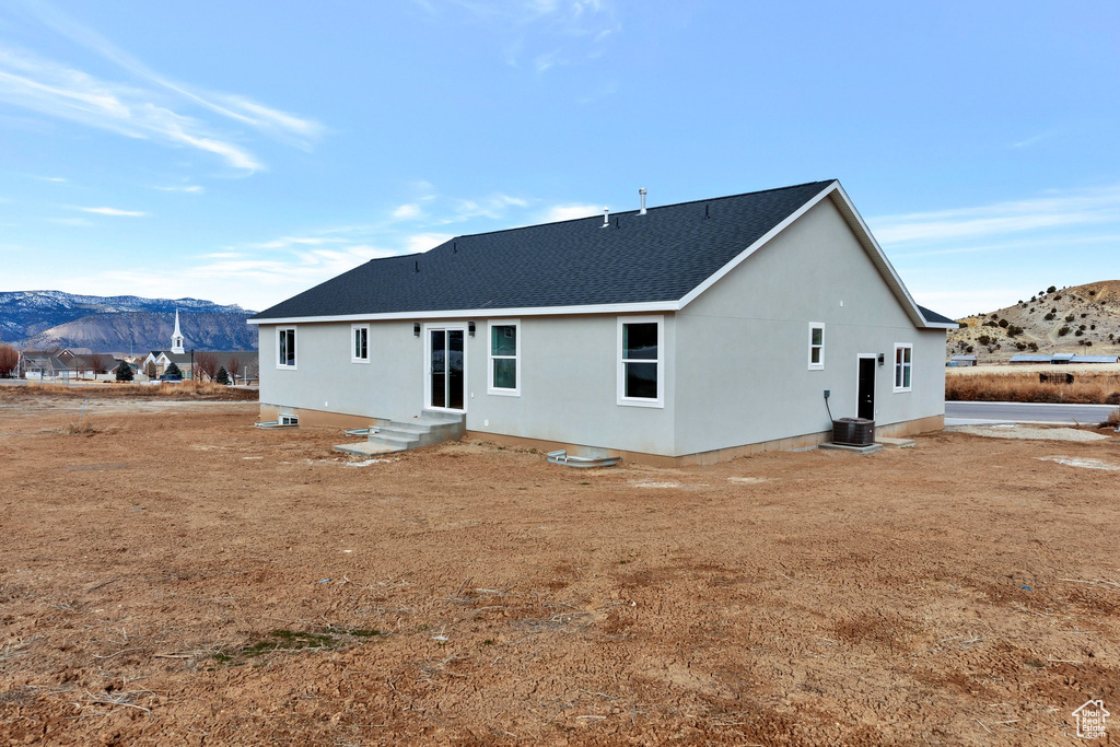 Rear view of property with cooling unit and a mountain view