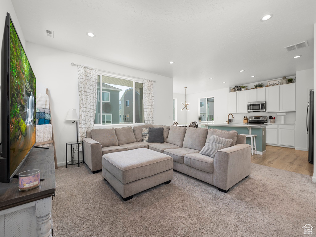 Living room with light hardwood / wood-style flooring and a chandelier