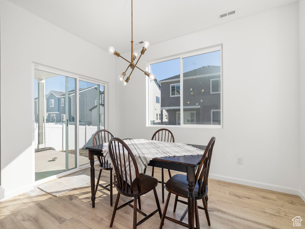 Dining space with a chandelier and light hardwood / wood-style floors