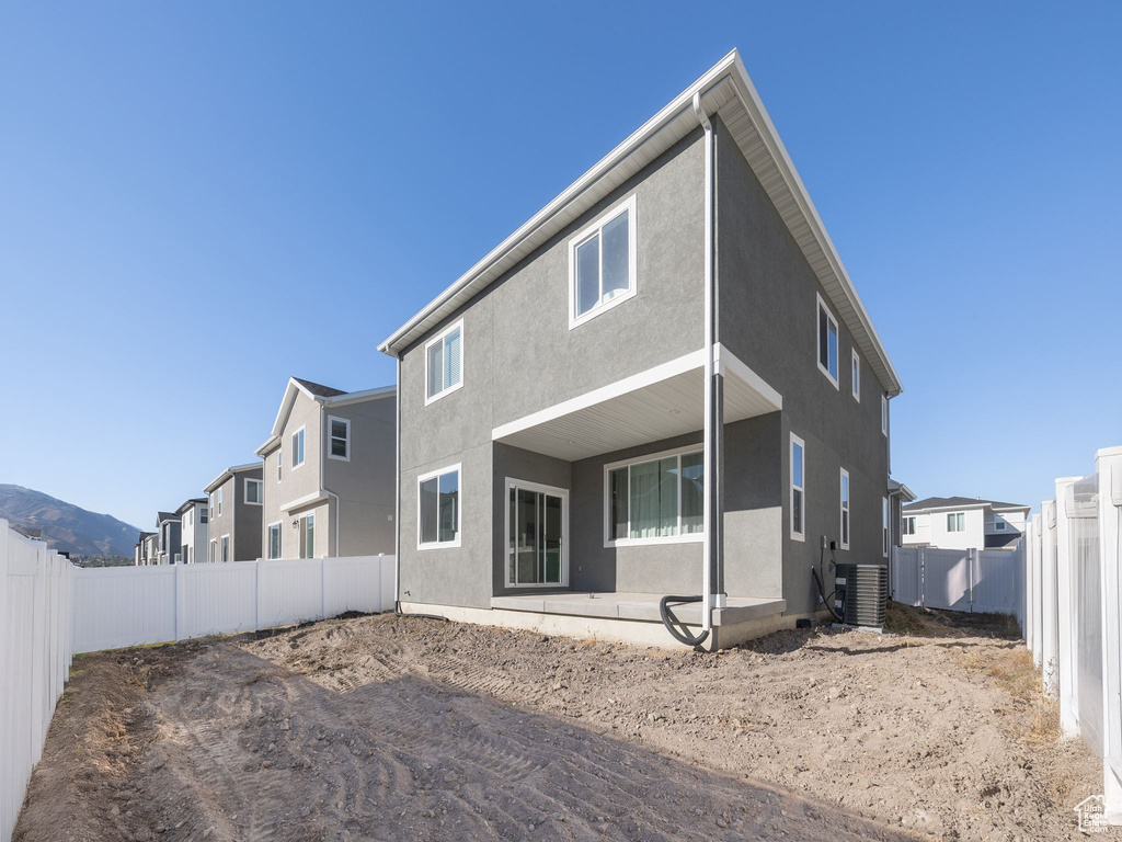 Rear view of property featuring central AC unit