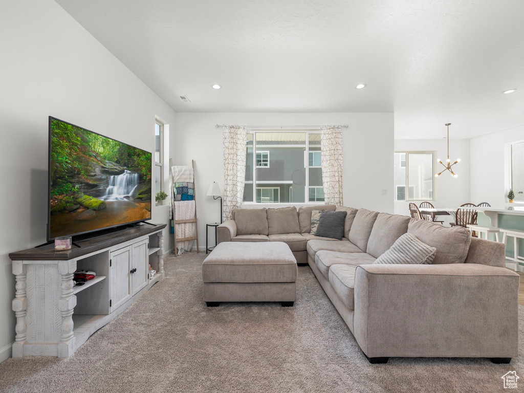 Living room with light carpet and an inviting chandelier