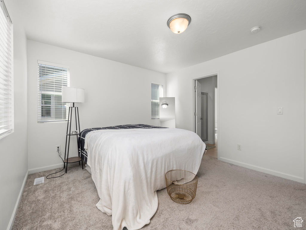 Bedroom featuring light colored carpet