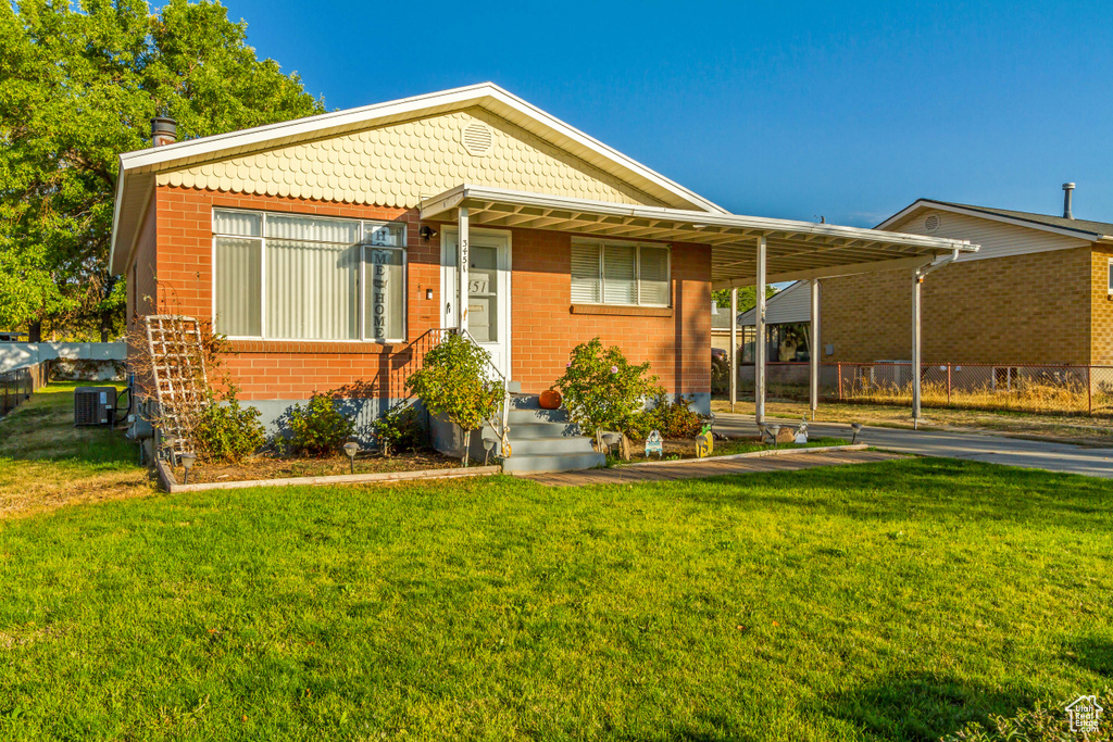 View of front facade with cooling unit and a front lawn