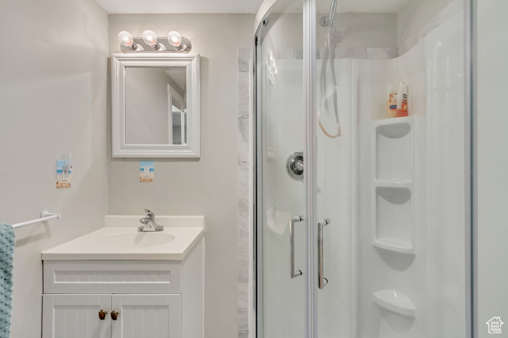 Bathroom featuring an enclosed shower and vanity