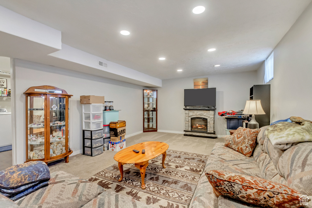 Living room featuring a fireplace, washer / clothes dryer, and light colored carpet