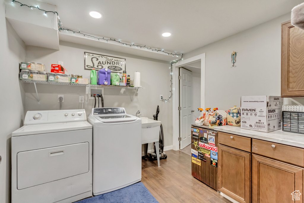 Laundry area with light wood-type flooring and independent washer and dryer