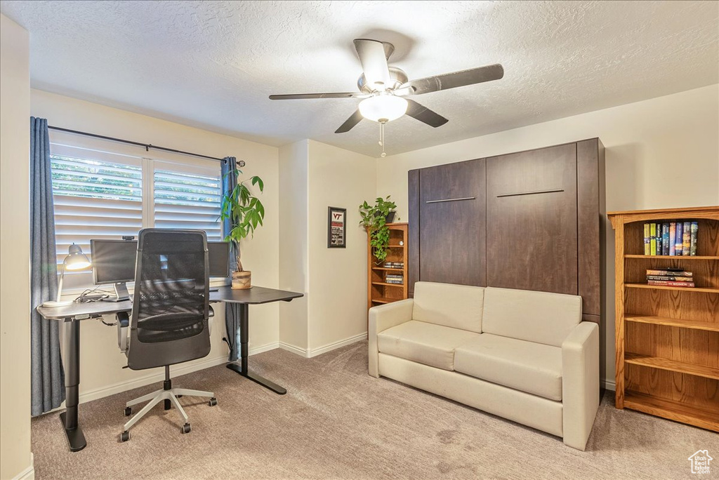 Office area featuring light carpet, a textured ceiling, and ceiling fan