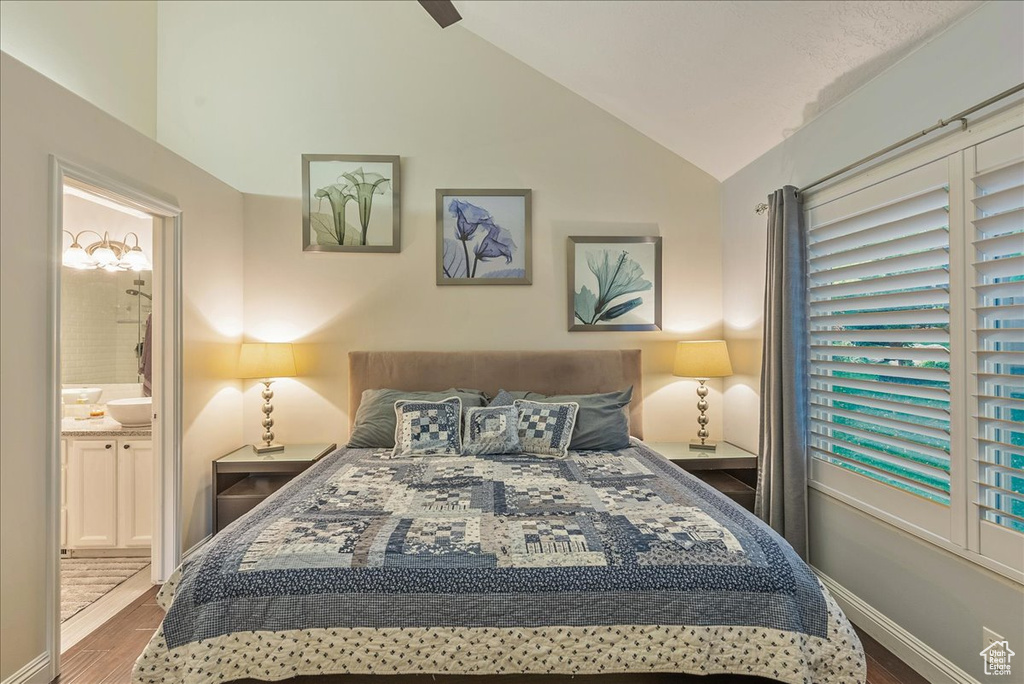 Bedroom featuring ceiling fan, lofted ceiling, hardwood / wood-style floors, and ensuite bathroom