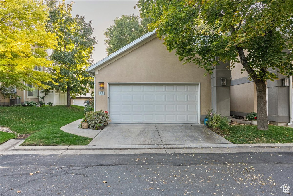 View of front of house with a front yard and a garage