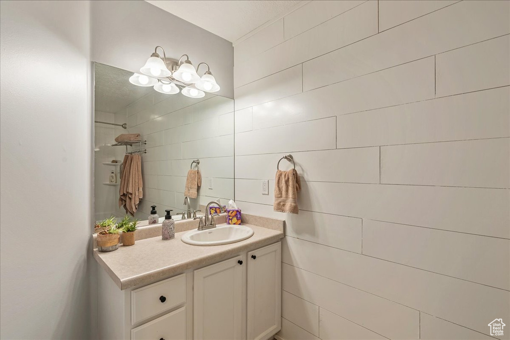 Bathroom featuring vanity and tile walls