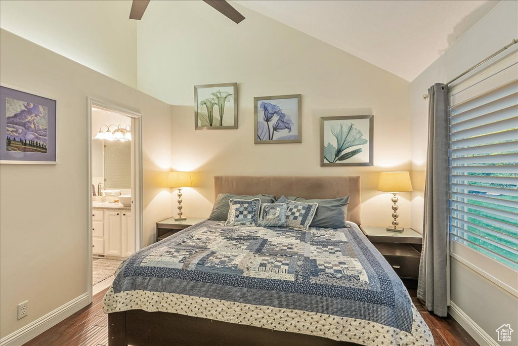 Bedroom featuring lofted ceiling, connected bathroom, dark hardwood / wood-style flooring, and ceiling fan