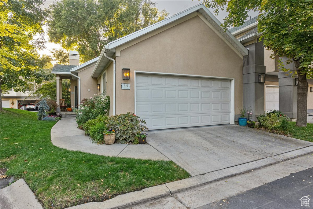 View of front of property featuring a garage and a front lawn