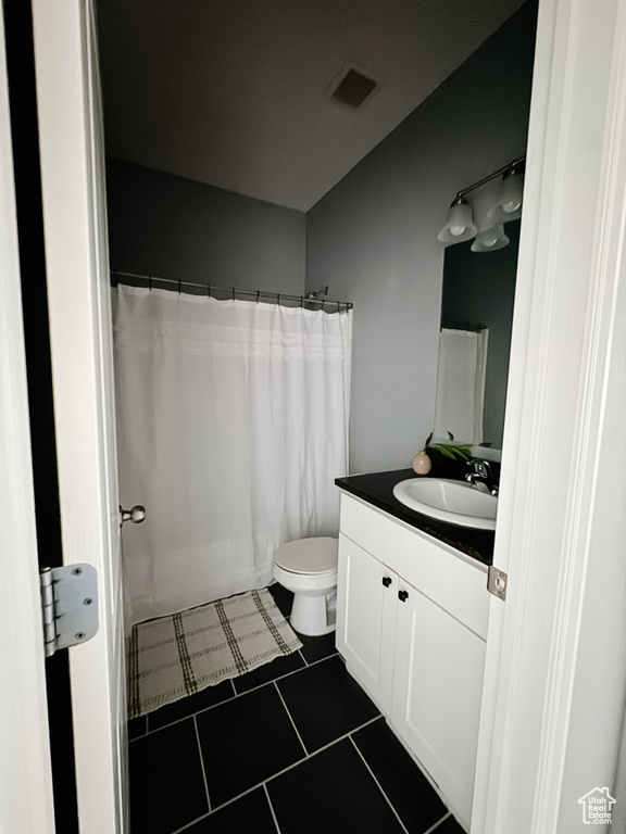 Bathroom featuring vanity, a shower with curtain, toilet, and tile patterned floors