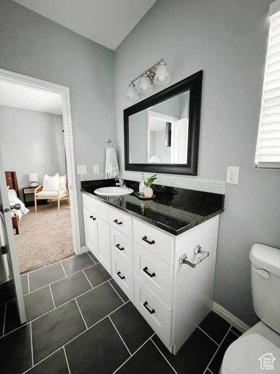 Bathroom featuring vanity, toilet, and tile patterned flooring