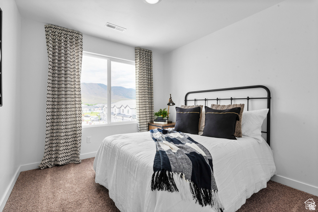 Carpeted bedroom with a mountain view