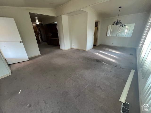 Interior space featuring light colored carpet, lofted ceiling, and a chandelier