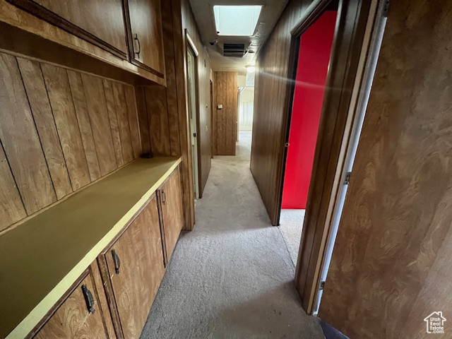 Corridor with wooden walls and light colored carpet