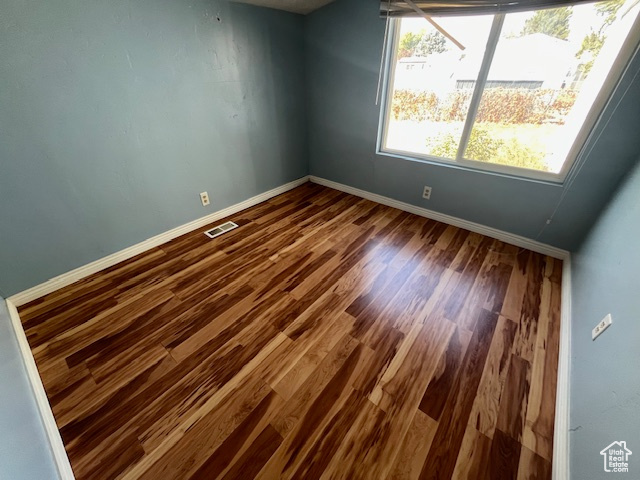 Empty room featuring wood-type flooring