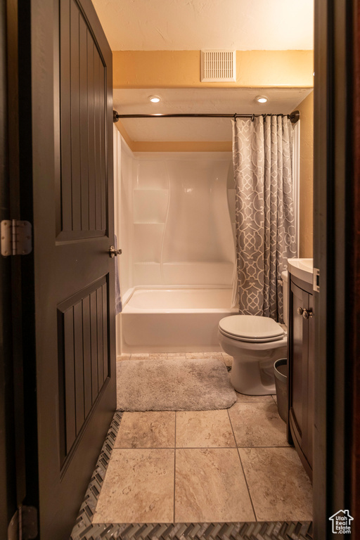 Full bathroom with tile patterned flooring, shower / bath combo, vanity, and toilet