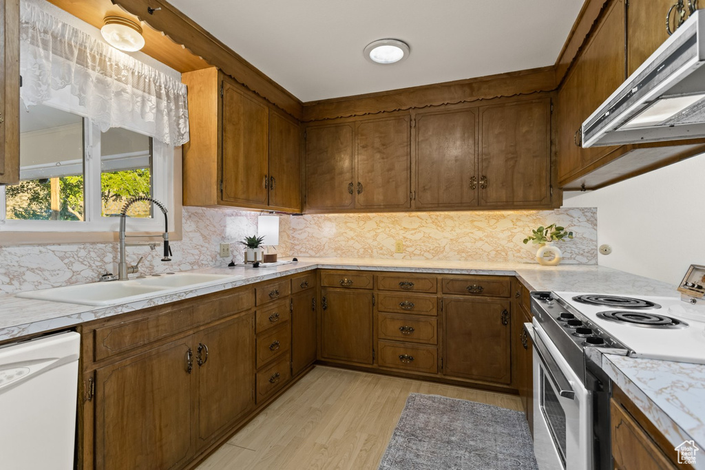 Kitchen with range, sink, light hardwood / wood-style floors, extractor fan, and dishwasher