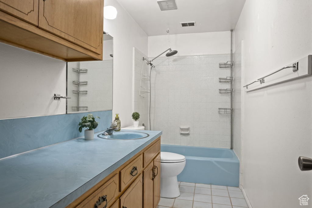 Full bathroom with tiled shower / bath, vanity, tile patterned flooring, and toilet