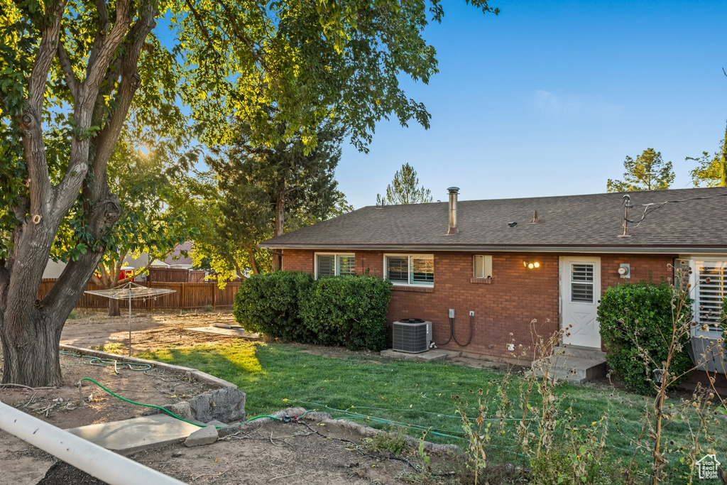 Back of house featuring a yard and central air condition unit