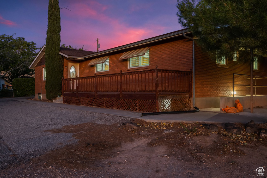 Property exterior at dusk with a wooden deck