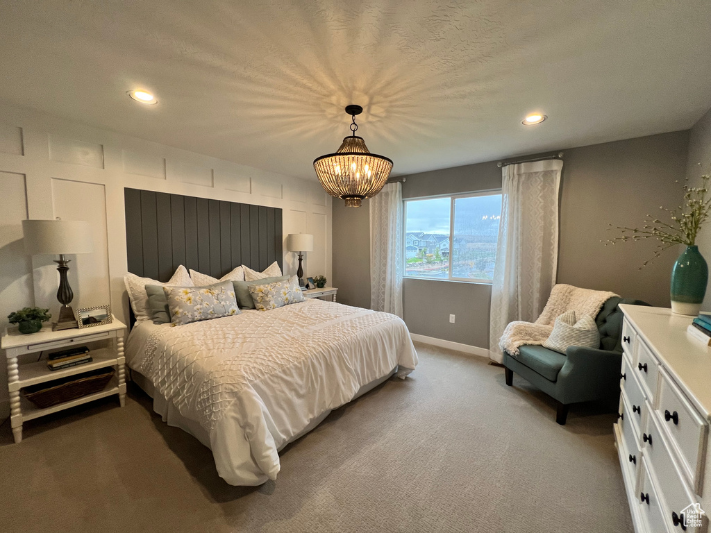 Bedroom featuring an inviting chandelier and carpet