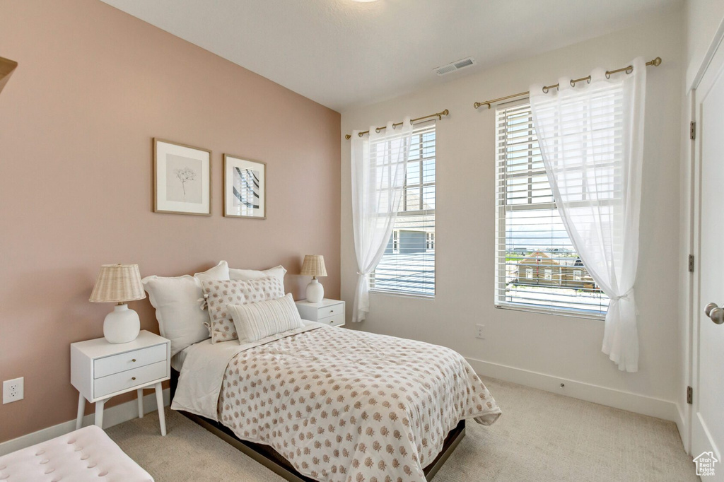 Carpeted bedroom with multiple windows