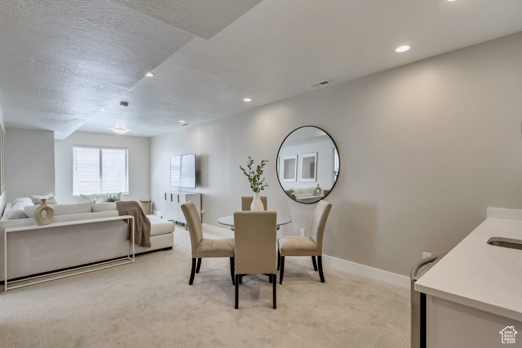 Dining room with a textured ceiling and light colored carpet