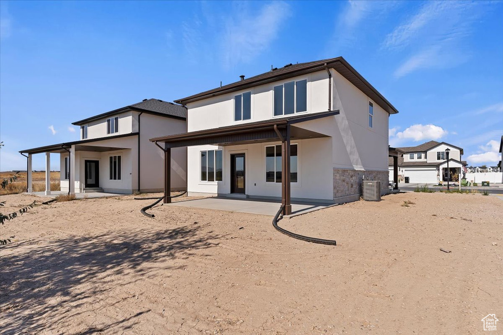 Rear view of house featuring central AC and a patio area