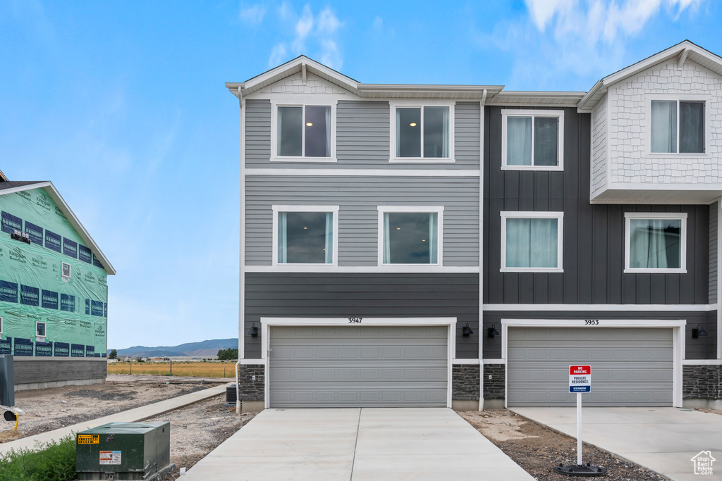 View of property featuring a mountain view and a garage