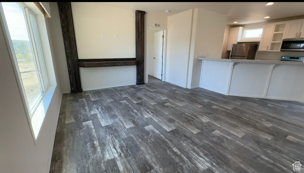 Kitchen featuring dark wood-type flooring, white cabinets, and appliances with stainless steel finishes