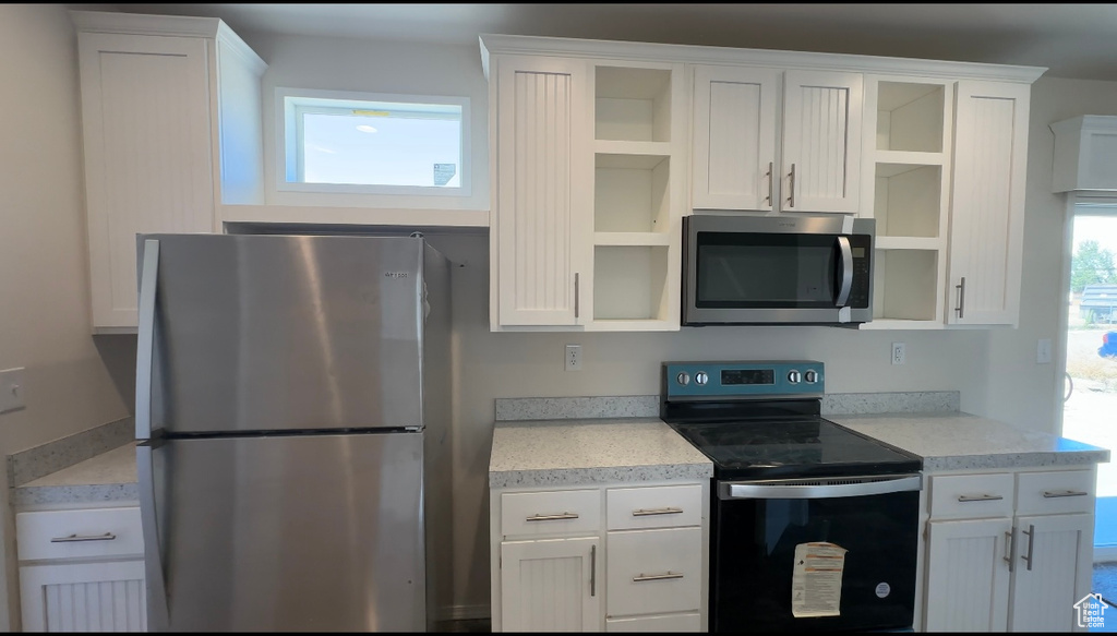 Kitchen featuring appliances with stainless steel finishes and white cabinetry