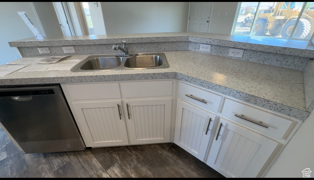 Kitchen featuring dishwasher, dark hardwood / wood-style floors, sink, and white cabinetry