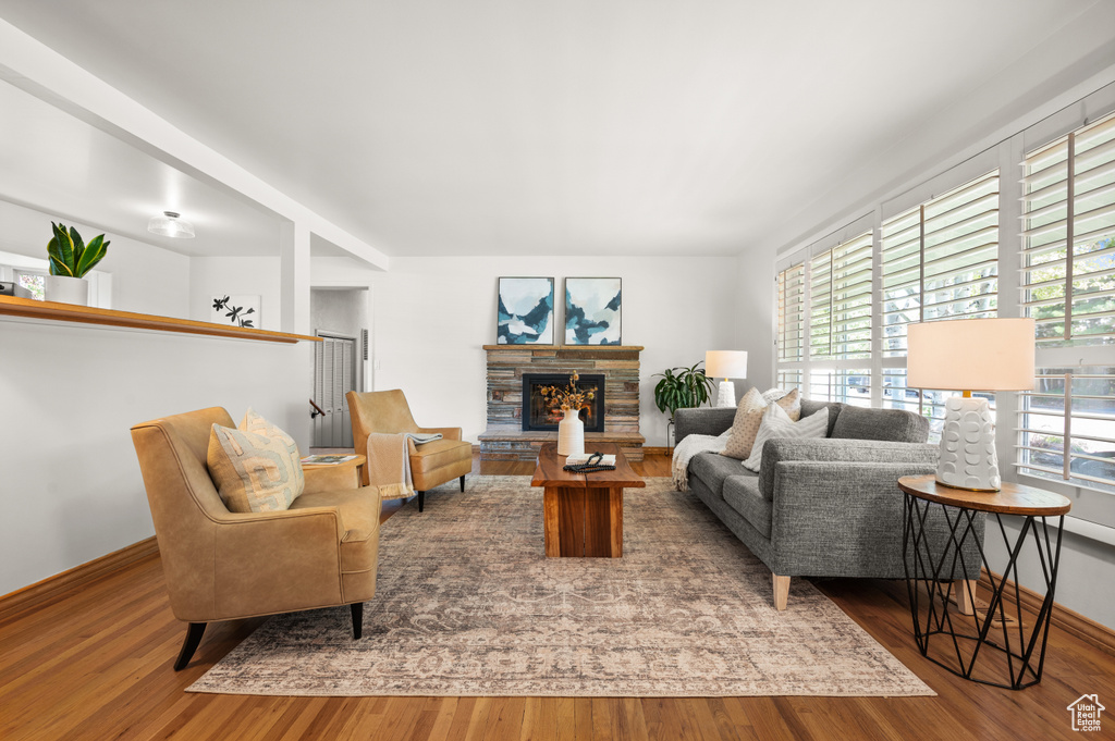 Living room featuring hardwood / wood-style flooring and a stone fireplace