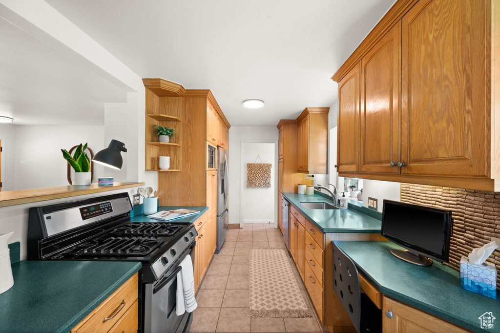 Kitchen with stainless steel appliances, sink, and light tile patterned floors