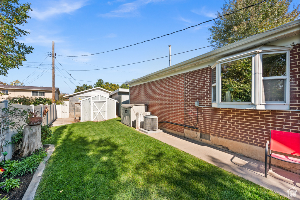 View of yard featuring central AC unit and a shed