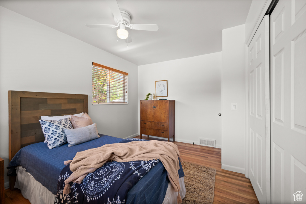 Bedroom with ceiling fan, a closet, and dark wood-type flooring