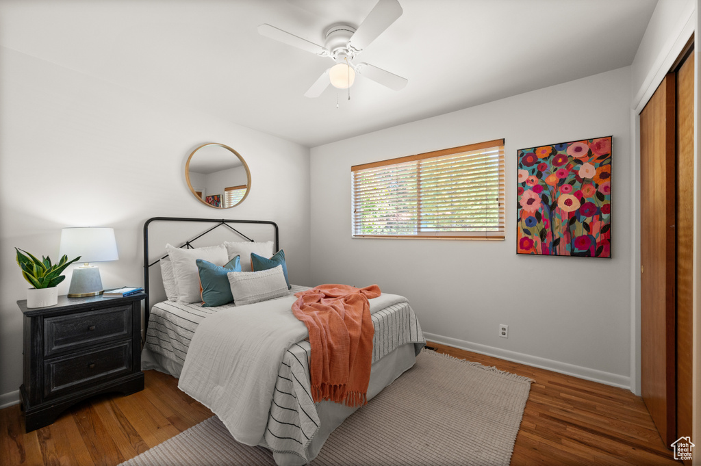 Bedroom featuring dark wood-type flooring, a closet, and ceiling fan