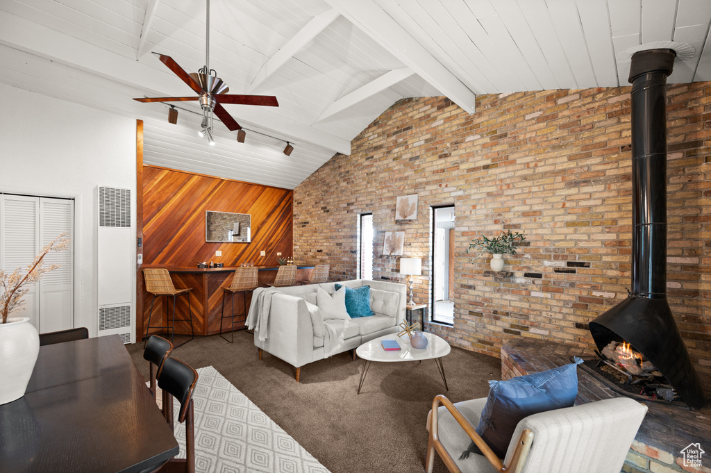 Living room with brick wall, beam ceiling, high vaulted ceiling, and ceiling fan