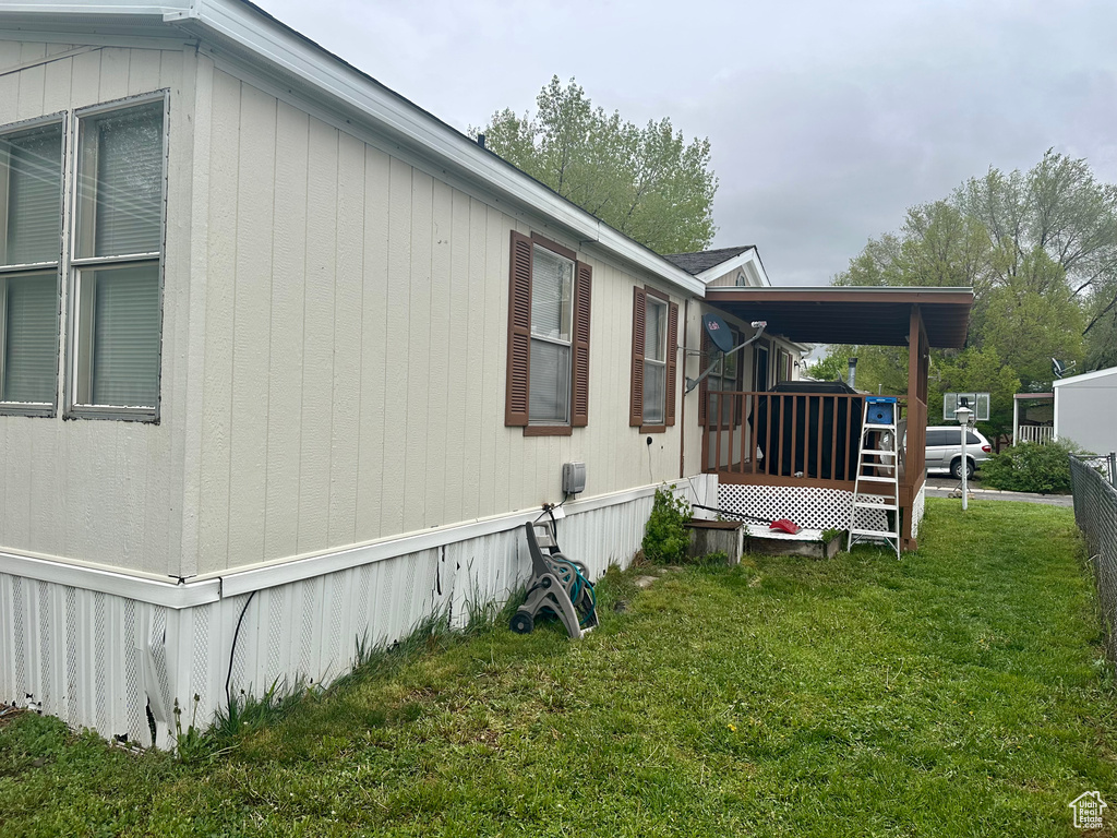 View of property exterior with a deck and a lawn