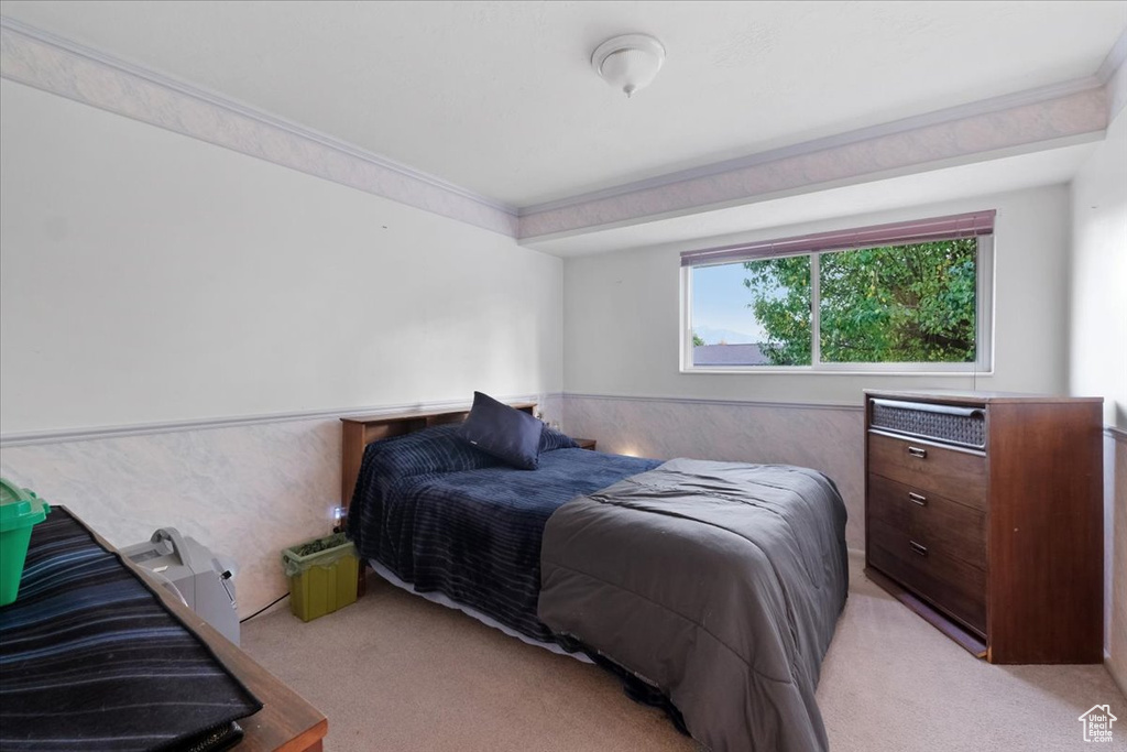 Carpeted bedroom featuring crown molding