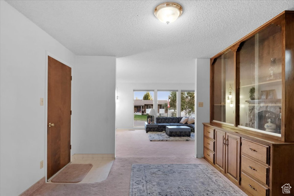 Hall with a textured ceiling and light carpet