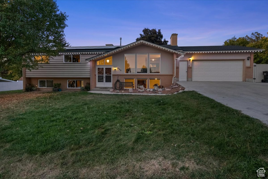 View of front of home featuring a lawn and a garage