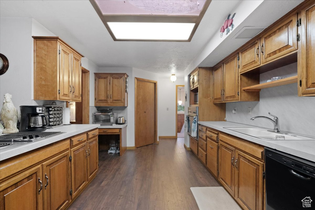 Kitchen with decorative backsplash, oven, sink, dark hardwood / wood-style flooring, and black dishwasher