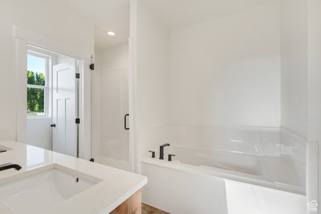 Bathroom featuring separate shower and tub and vanity