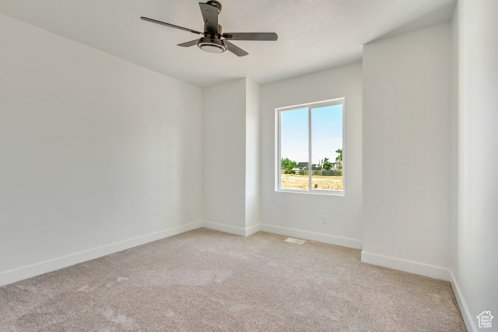 Carpeted spare room with ceiling fan