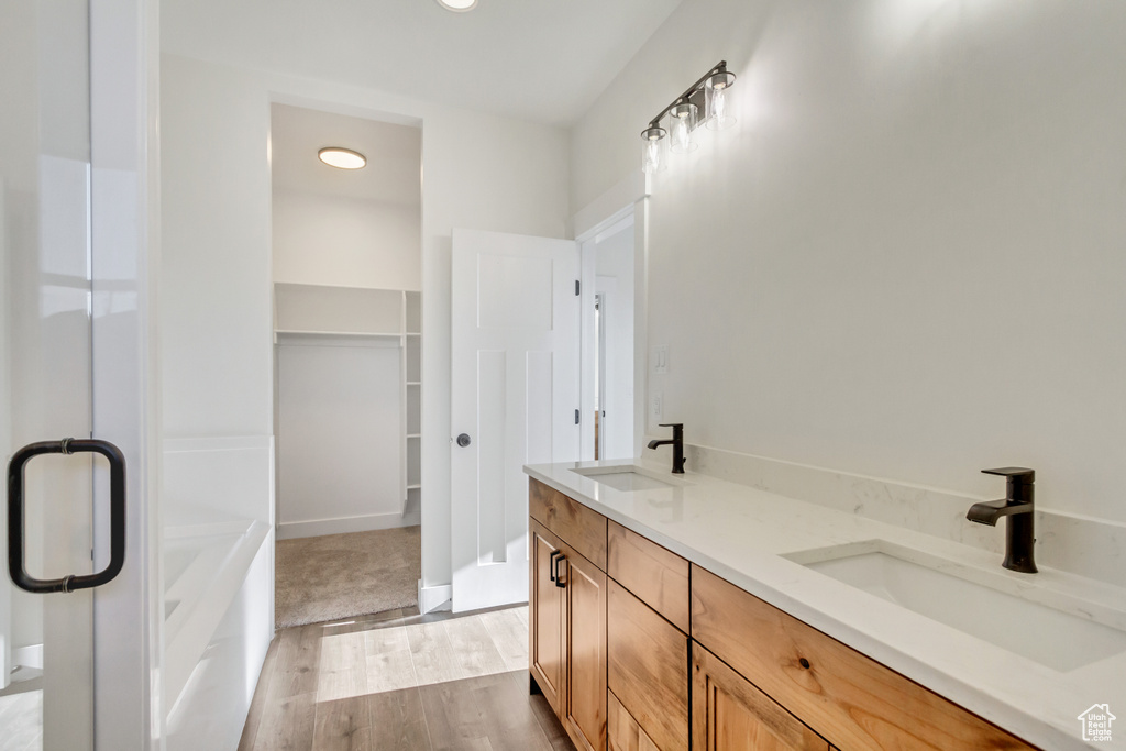 Bathroom featuring a bathtub, vanity, and hardwood / wood-style floors