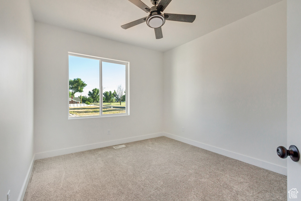 Carpeted spare room with ceiling fan